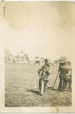 Man dressed as a Native American caricature walks past a photographer.