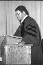A man speaks from a pulpit.