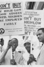 William Cousins, Dick Gregory, and Jesse Jackson are shown holding signs at an Operation Breadbasket protest regarding High-Low Food Stores. Written on verso: Ald. Wm. Cousins, Dick Gregory, Jesse Jackson - High Low protest