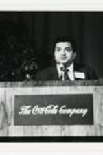 View of Dr. Donald Mitchell Stewart speaking at podium. Written on verso: Dr. Donald Mitchell Stewart speaking at Coca-Cola Co. event (member of the Board of Directors at Coca-Cola).