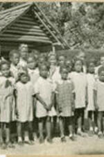 A group of Chadwick School pupils stand outside of a rustic shed.