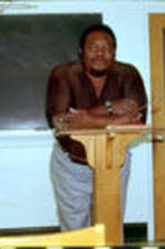 C. Eric Lincoln stands in front of a lectern in a classroom.