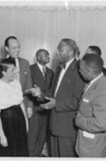 A man converses with a group at the President's reception. Written on verso: President's reception October 1, 1953.