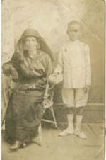 Portrait of a woman wearing a dark dress seated next to a young boy in a light suit. Written on verso: Maud and her little boy he is [?] years old.