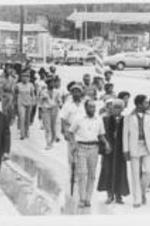 Joseph E. Lowery is shown with other demonstrators walking down a street as part of a march supporting SCLC's advocacy against police brutality in Chester, South Carolina.