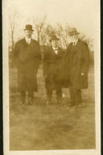 Three unidentified men standing together.