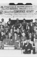 Bishop Desmond Tutu speaks at an International Conference Against Apartheid held at Ebenezer Baptist Church in Atlanta, Georgia. On the dais seated in the first row are, from left, Joseph E. Lowery, Eleanor Holmes Norton (to the right of Tutu, standing), an unidentified man, Coretta Scott King, and E. Randel T. Osburn.