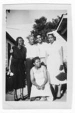 An unidentified group of people stand in a tight group for a group photo.