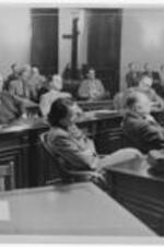 People sit in a courtroom.