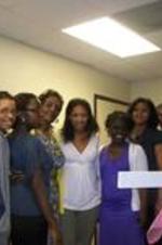 Spelman SIS students pose with Darlene Clark in front of a cross.