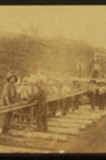 Men help rebuild railroads after the end of the Civil War. Text from slide presentation: After the War, rebuilding those railroads provided work for many freed slaves who had left their rural homes to seek opportunities in cities. This was the case for early residents of Reynoldstown. Most of the men worked in railyards, as firemen or laying track as depicted here. Many of the women who lived in Reynoldstown were employed as domestic workers.