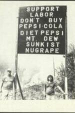 Two men stand underneath a sign discouraging the purchase of Pepsi products to support worker's rights. 1 page.