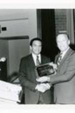 Hugh Gloster with Andrew Young. Written on verso: President Gloster presents a plaque to Atlanta Mayor Andrew Young, following a convocation in the Mayor's honor. January 21, 1982.