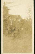 A group of men gather outside a house.