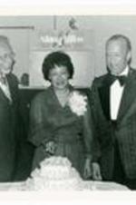President Hugh Gloster with wife Dr. Beulah Gloster and Thomas Kilgore cutting a 10th Anniversary cake. Written on verso: 10th Anniversary Party L-R Rev. Thomas Kilgore, Beulan Gloster, Dr. Gloster Feb. 1977.