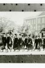 View of graduation procession. Written on verso: Class 1937 graduation on campus, Sisters Chapel, 4th in line of March is Ruth Scott Simmons; must credit Ms. Simmons if photo used.