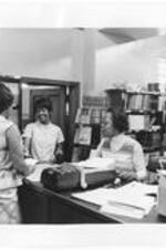 Three women talk to each other in the student bookstore.