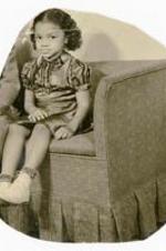 Beth I. Chandler as a child sitting on sofa. Written on verso: In new house at Fountain Dr. Age 3.