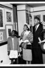 An unidentified family admire artwork at the 16th annual art exhibition.