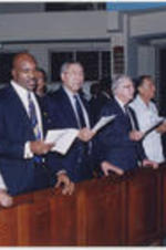 Joseph E. Lowery is shown standing with others including Evander Holyfield, Colin Powell, and Jimmy Carter (second thru fourth from left, respectively, after Lowery) at an event related to the election observation team for the Jamaican elections.
