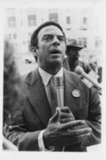 Andrew Young speaks at a rally to protest the United States' veto of a United Nations resolution condemning the South African invasion of Angola. Written on verso: South Africa -- Former U.N. Ambassador Andrew Young who is now a candidate for mayor of Atlanta, says America is inextricably bound with the rest of the world, and that "we must see this reflected in U.S. policies, or we'll feel it in our pocketbooks."