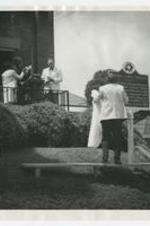 Exterior view of man unveiling historic site sign at Bethel AME Church with a man standing at a podium.