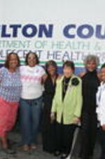 Evelyn G. Lowery poses for a photo with others in front of a Fulton County Department of Heath &amp; Wellness vehicle at a Pampering For Peace event held at D'Lor Salon &amp; Spa in Atlanta, Georgia in recognition of National Domestic Violence Awareness Month.