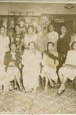 A group of unidentified women sit and stand together for their picture.