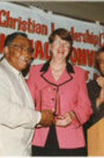 Southern Christian Leadership Conference (SCLC) President Joseph E. Lowery presents an award to U.S. Attorney General Janet Reno at the 39th Annual SCLC Convention in Detroit, Michigan. Claud Young and John Nettles stand at right.
