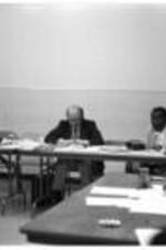 A man speaks during a VEP meeting, while other people listen and take notes.
