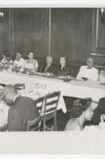 Indoor view of people seated at banquet table, on sign: 1946.