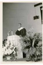 President Jerome Holland, Hampton Institute, speaks at a podium.