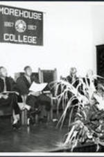 Brailsford R. Brazeal sits on stage at a Morehouse College commencement. Left to right: Dr. Brailsford R. Brazeal, Dr. Martin Luther King, Jr., [unidentified], Benjamin E. Mays, [unidentified speaker].