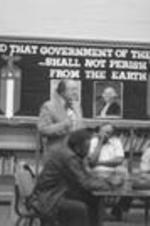 A man speaks at a VEP event held in a library.