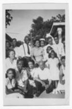 An unidentified group of people stand in a tight group for a group photo.