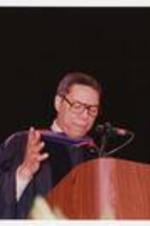 Colin Powell stands at a podium at the summer commencement.