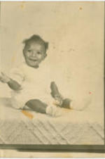 A child sits on a cloth.