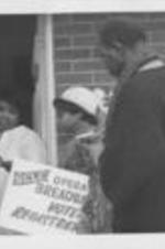 Operation Breadbasket workers are shown speaking to residents at a house.