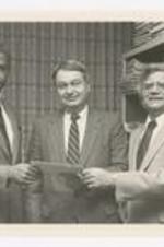 Dr. Thomas Cole and two other men pose with a check.