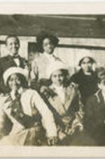 Nora E. Floyd sits with a group of unidentified young men and women.