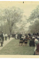 A crowd gathers outside for a commencement ceremony.