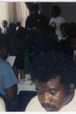 Bobby Bean eating at a banquet during an internal campaign. Written on verso: 1988 Internal campaign Kim Yarber, Bobby Bean.