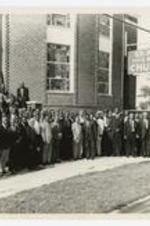 Outdoor group portrait of men and women in front of a church.