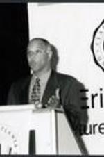 An unidentified man speaks from the podium.