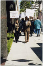 Evelyn G. Lowery and other demonstrators hold protest signs outside of the William Morris Agency in Beverly Hills, California.