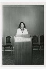 Portrait of a woman at a podium, on podium: Cabana.