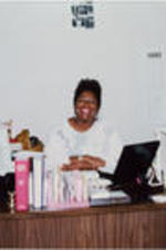 An unidentified woman is shown posing for a picture in an office at the SCLC/W.O.M.E.N. Learning Center.