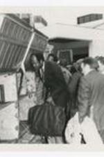 The Board of Trustees load luggage onto a bus. Written on verso: CC Clark College - Board of Trustees, Left to right: 1. Dr. Elias Blake, Jr., 2., ca 1979.