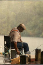 C. Eric Lincoln sits and fishes in the rain at Alex Haley's Farm.