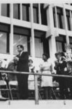 Ralph D. Abernathy (behind podium), Senator Ted Kennedy, Evelyn G. Lowery, Juanita Abernathy, and others are shown clapping on a stage during a Poor People's Campaign event in Memphis, Tennessee.